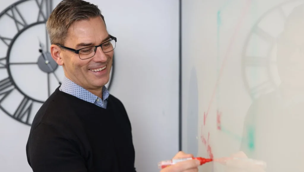 VD Peter Malmberg skriver på en whiteboard i konferensrummet på webbyrån decision by heart i karlstad