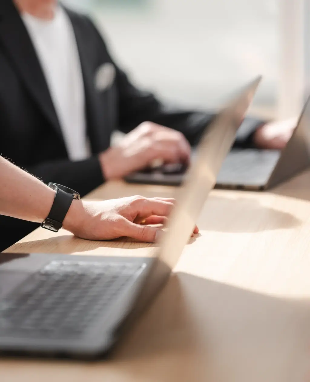 Närbild av del av vårt team som arbetar tillsammans vid datorn - en del av vårt arbete med sökmotoroptimering (SEO).