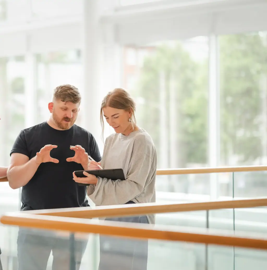 Kim Persson och Cecilia Ljungquist tittar på en surfplatta som används i arbetet med webbdesign.